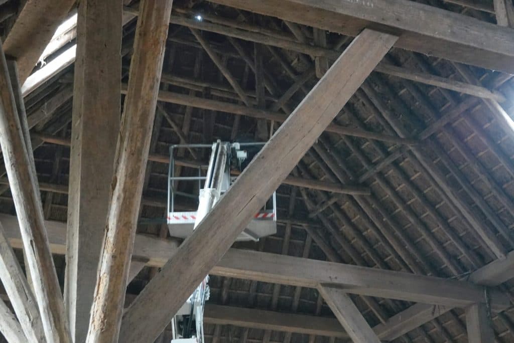 Hoogwerker bij de dakbalken in de woonboerderij in Baaium